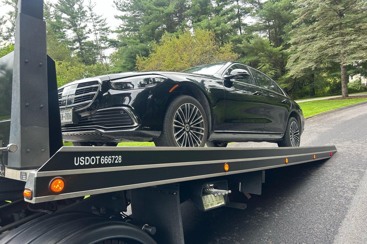 Black sedan on an AG flatbed